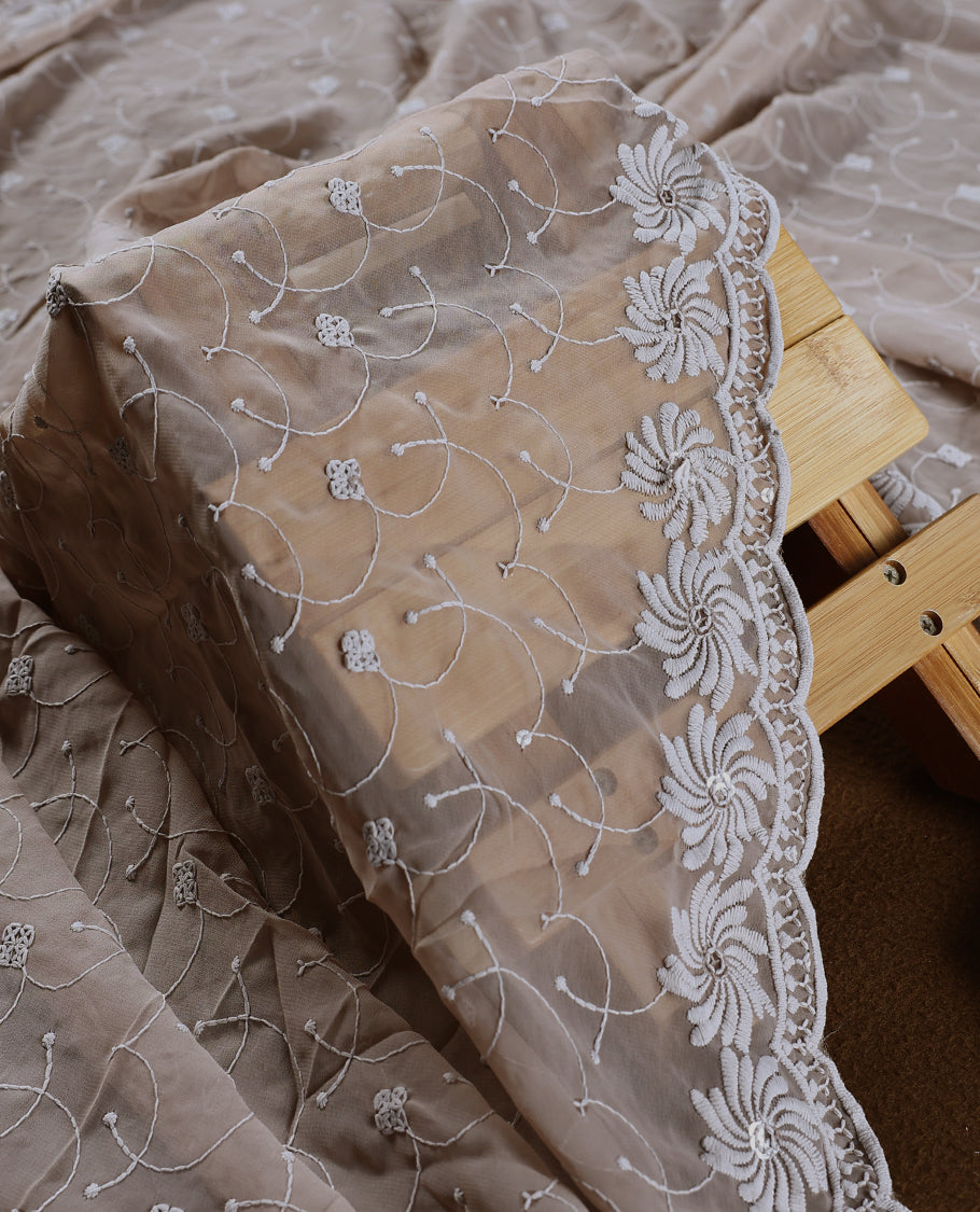 Graceful Taupe colour churidhar material adorned with intricate white floral embroidery and delicate thread patterns, paired with a plain matching bottom and embroidered dupatta, perfect for festive and elegant occasions