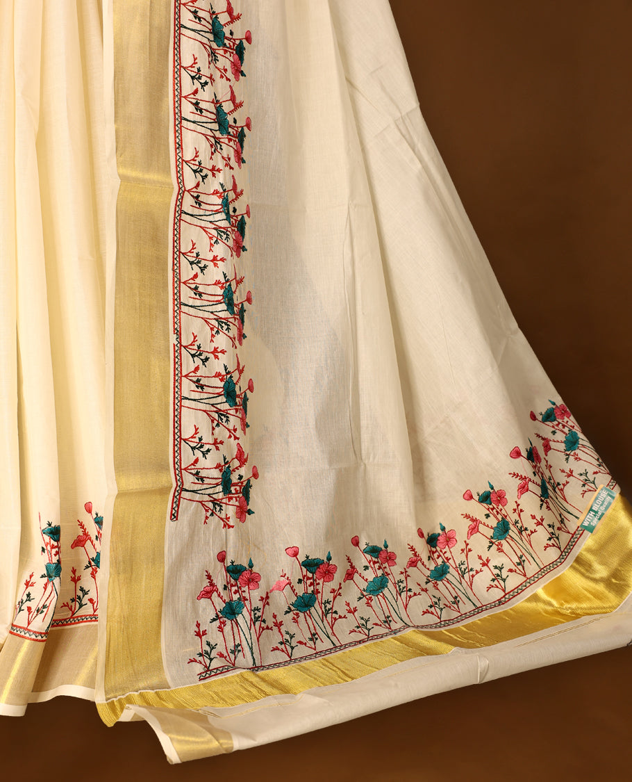 Light Gold colour Cotton Kerala saree featuring Plain body and a beautifully woven Gold Kasavu border with Heavy Green and Pink colour Floral embroidery work, paired with a matching blouse perfect for festive occasions.