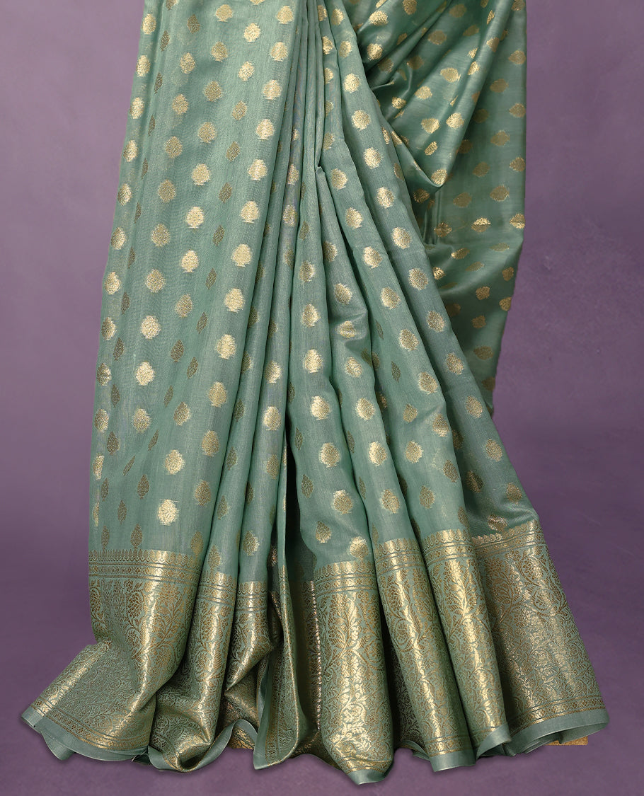 Light Aqua colour pure Banarasi Chanderi cotton, beautifully adorned with traditional antique zari Small Butta designs across the body, completed with a hand-dyed colour, a traditional border, and a matching blouse.