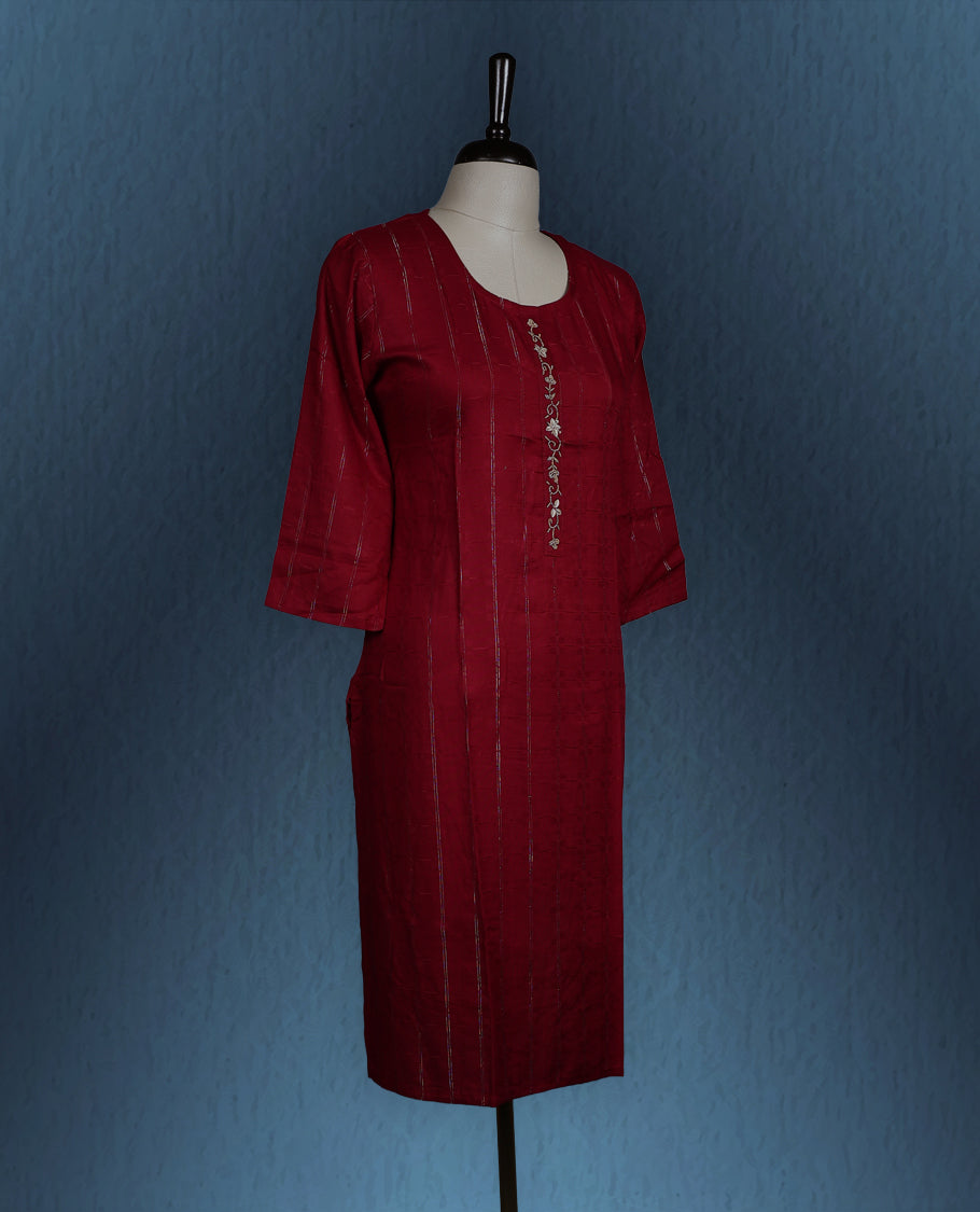 Maroon colour kurti with subtle vertical self stripes, adorned with delicate golden thread embroidery along the front placket, featuring a round neckline and stylish three quarter sleeves.