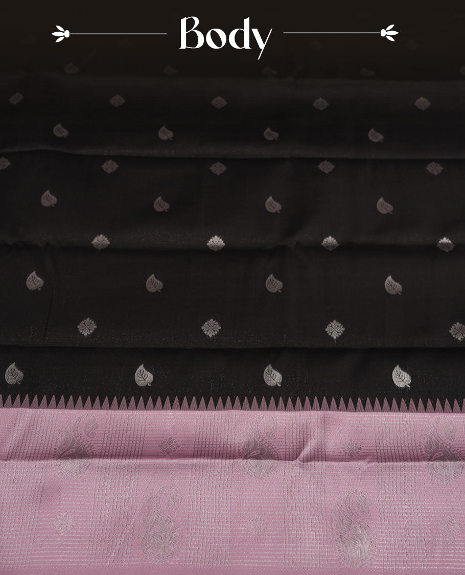 Black colour semi silk saree adorned with subtle silver zari motifs on the body, complemented by a pastel pink pallu intricately woven with rich floral patterns border and pallu, and paired with a matching blouse