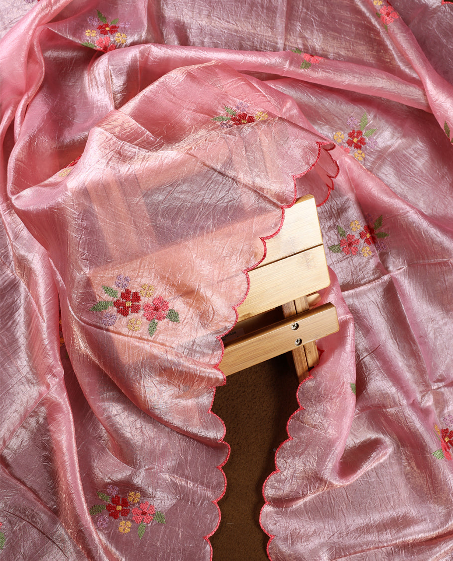 Baby pink colour churidhar material with elegant floral embroidery on the neckline and scalloped edges, paired with a plain matching bottom and a dupatta highlighted with floral motifs.