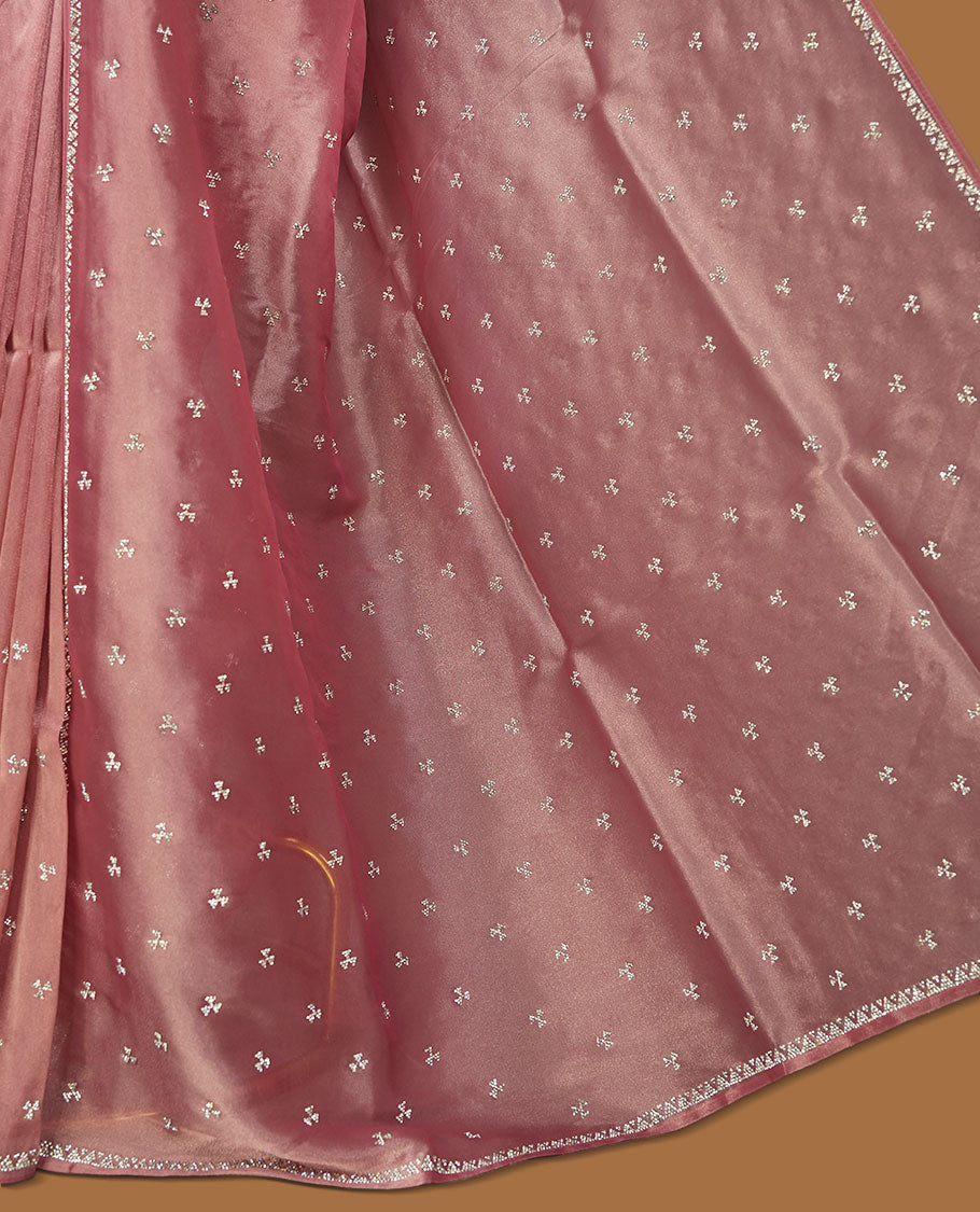 Pastel Pink Colour net shimmer fancy saree adorned with scattered white stone buttas all over the body, paired with a delicate stone worked border and matching blouse featuring floral vine stone embroidery