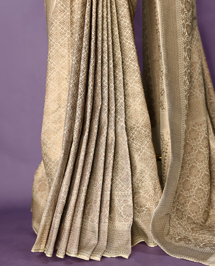 Off White colour semi Banaras Katan saree featuring an antique Gold zari jacquard body, complemented by a self colour traditional border with a floral kodi design, paired with a matching blouse