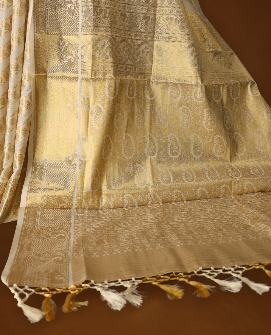 Elegant off white colour soft cotton Kerala saree featuring golden paisley and floral motifs in diagonal stripes, enhanced by a rich golden pallu with tassels, paired with a matching blouse, perfect for traditional and festive occasions.