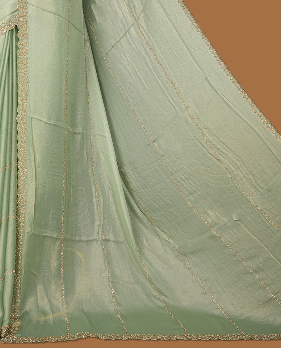 Pastel Green colour net shimmer fancy saree adorned with white stone buttas, paired with a delicate stone worked border and matching blouse.
