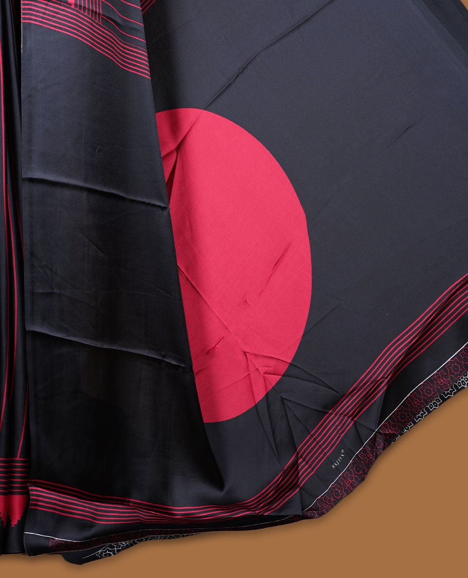 Black colour semi modal saree highlighted with red triangle border accents and sleek striped detailing across the drape, featuring a bold oversized red circular motif on the pallu, paired with a matching printed blouse.