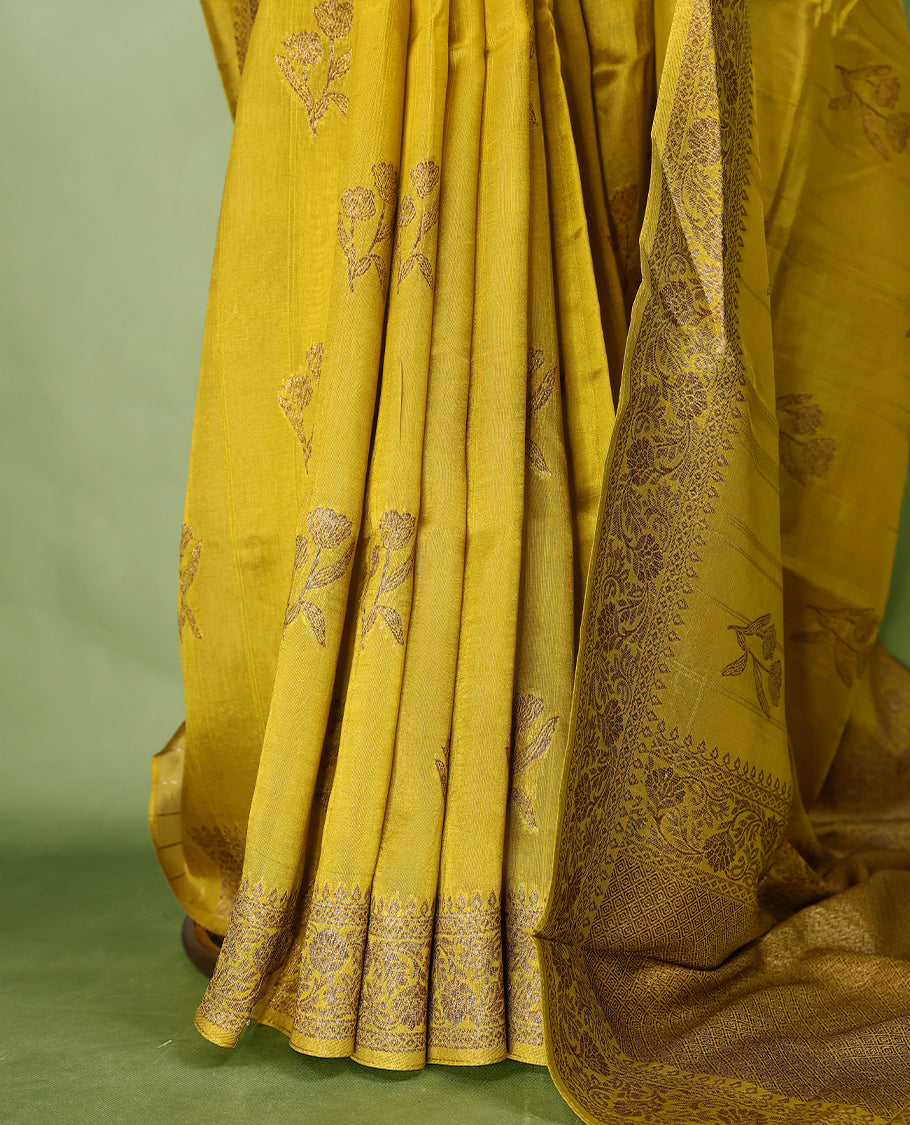 Dark Mustard colour semi Banaras tussar georgette saree embellished with antique zari flower motifs across the body, complemented by a rich Banaras border and paired with a matching blouse.