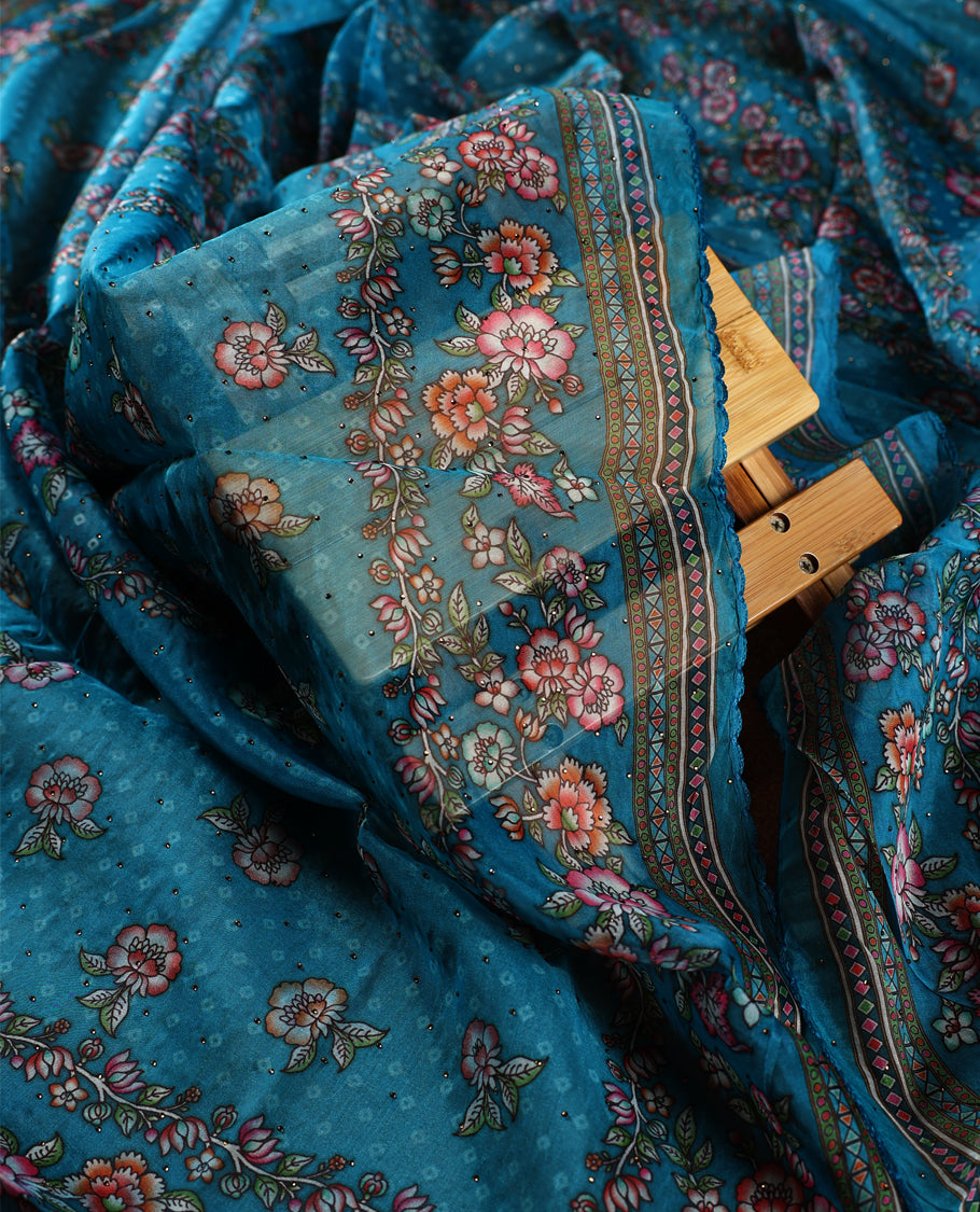 Turquoise blue churidhar material adorned with delicate floral, stone and vine prints, enhanced by a contrast border & Paired with a plain matching bottom, perfect for festive wear and casual elegance.