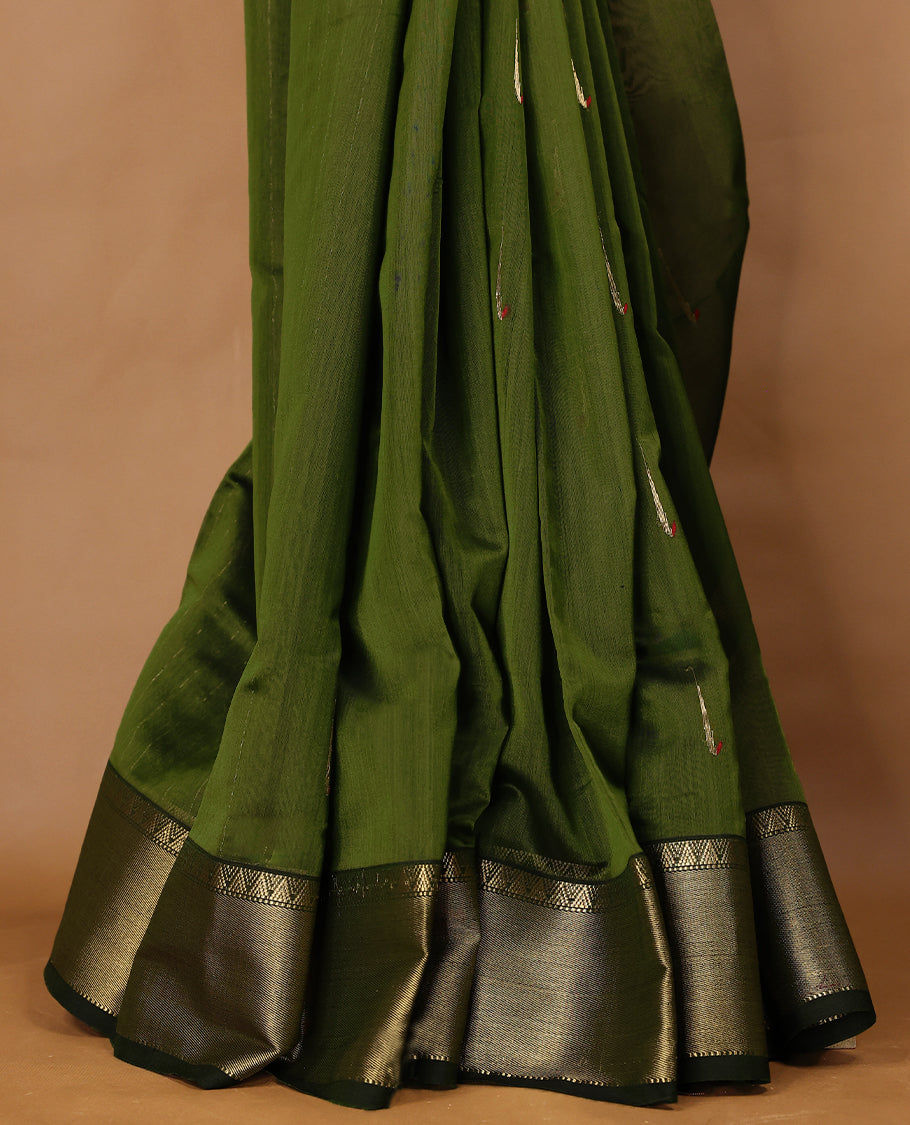 Olive Green coloured Maheshwari Cotton saree featuring antique Zari motifs across the entire body, complemented by a traditional gold coloured border and a matching blouse.