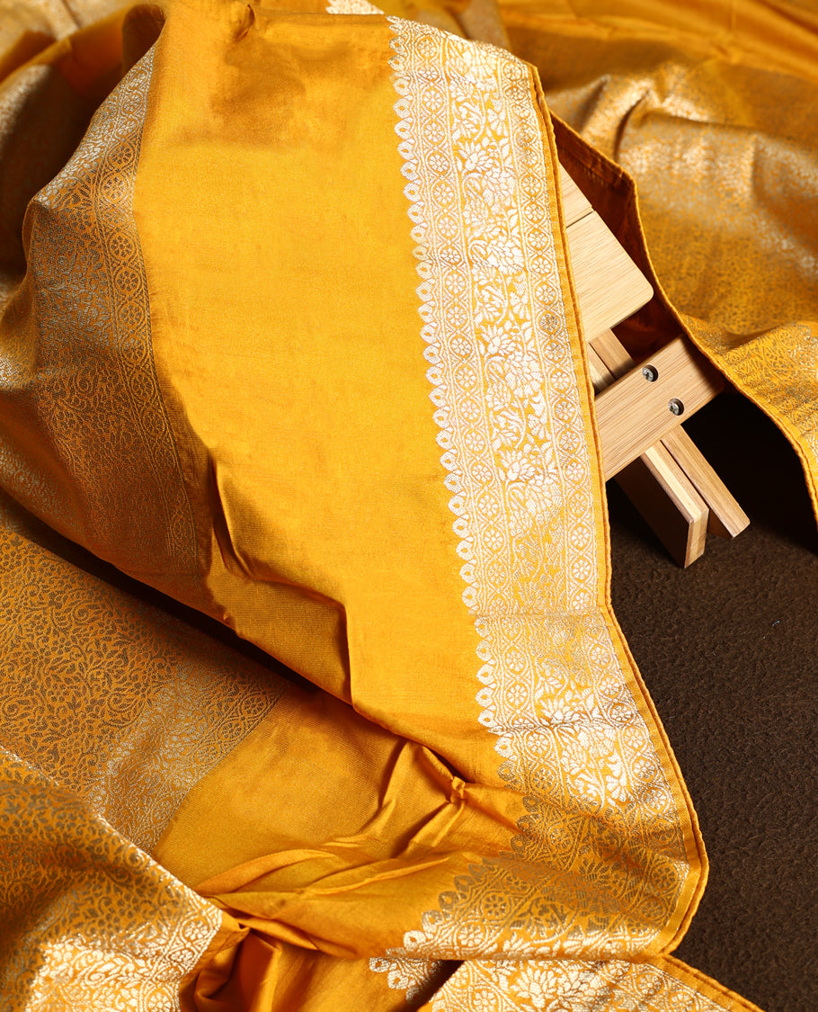 Yellow colour churidhar material with golden zari floral patterns and sparkling stone work, paired with a plain matching bottom and dupatta.