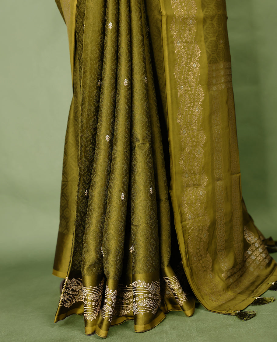 Olive Green colour pure Banaras crepe saree showcases elegant Gold & Silver zari Motifs all over the body, a traditional gold & Silver zari border, a rich intricately woven pallu, and comes with a matching blouse.