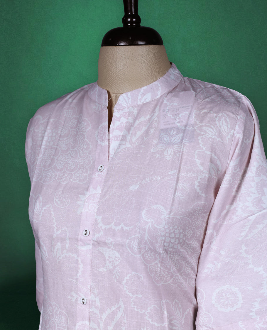 Baby pink colour cotton kurti with subtle self printed floral patterns, featuring a mandarin collar, front button down design, and elbow length sleeves a soft and graceful choice for everyday elegance.