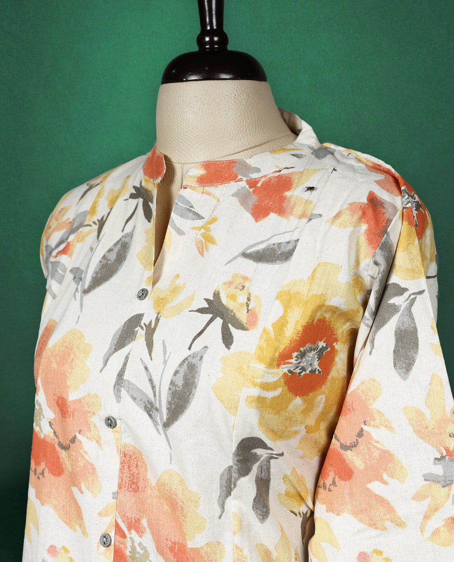 Off White colour kurti highlighted with vibrant orange, yellow, and grey floral prints, featuring a round neckline with a front slit and elbow length sleeves, cheerful and breezy pick for daytime wear.