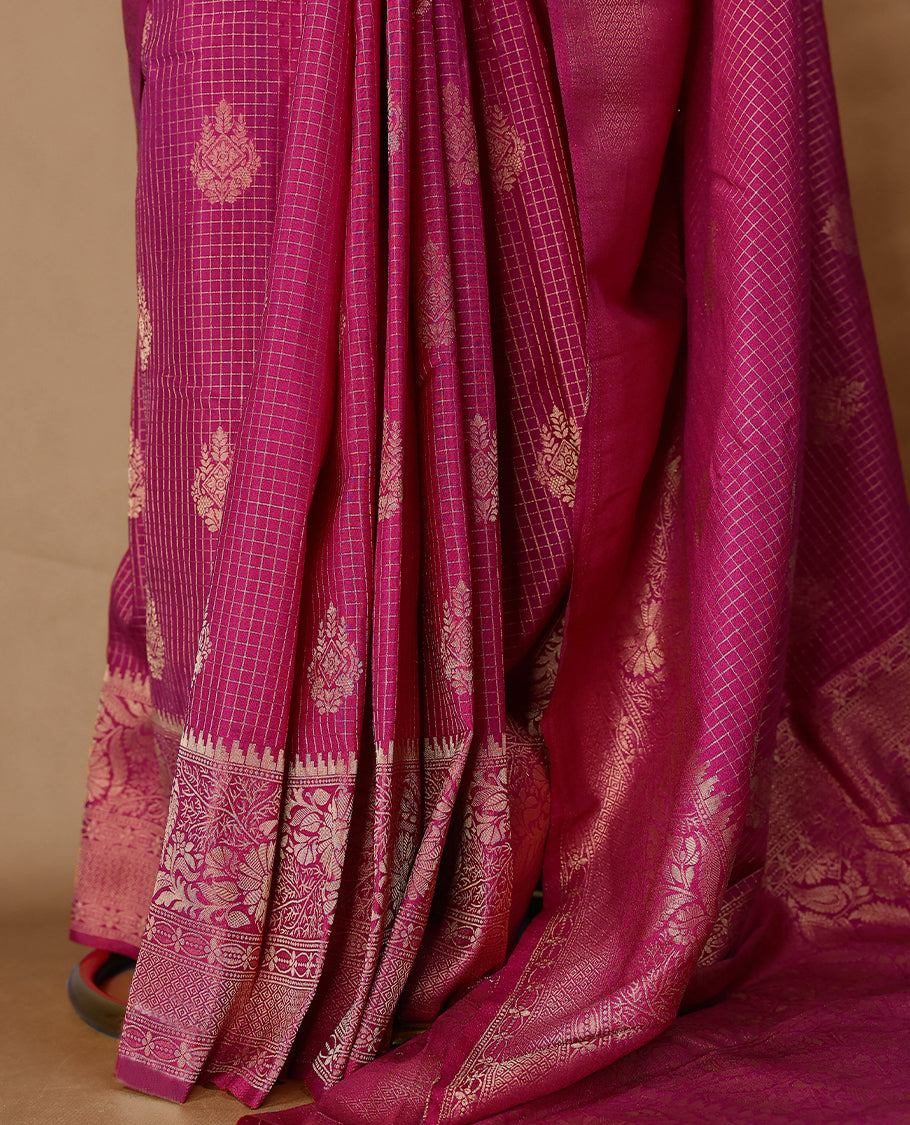 Rani Pink coloured semi Banaras georgette saree featuring golden Zari checks with floral motifs on the body, complemented by a self coloured traditional border with floral kodi design and a matching blouse.