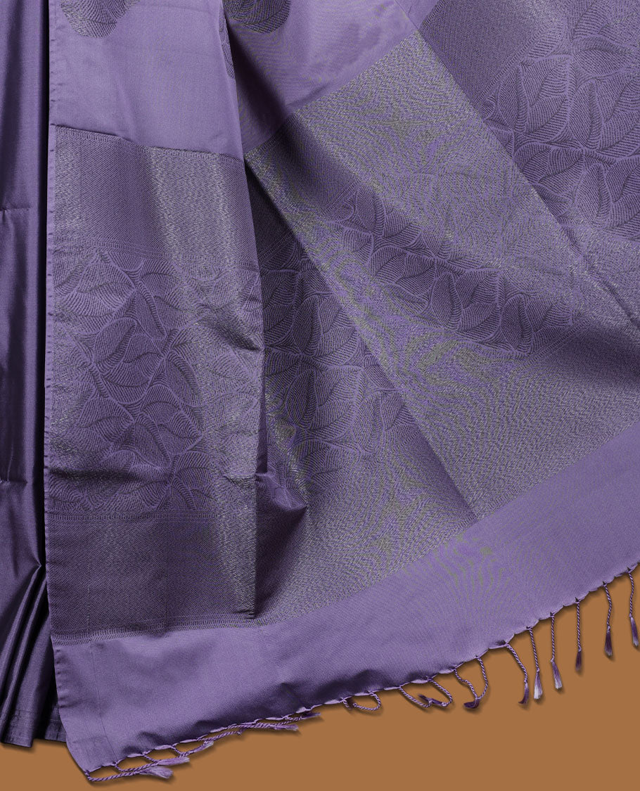 Pastel purple colour semi soft silk saree adorned with delicate woven floral kodi motifs on the body, complemented by a Self colour woven pallu with intricate detailing and tassel accents without border & Comes with a matching blouse piece.