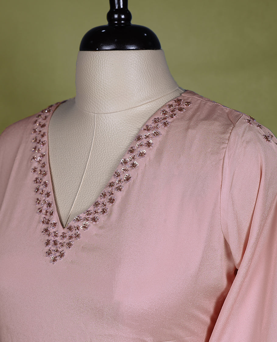 Baby pink coloured stylish kurti with slit, featuring a V neck design adorned with cut beads and sequin work, for women