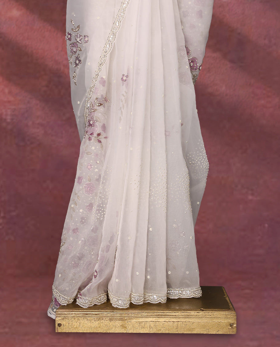 White colour pure organza saree featuring Grape Colour floral prints with intricate bead and sequin work across the body, adorned with a matching embellished border, complemented by a worked pallu and paired with a heavily worked matching blouse.