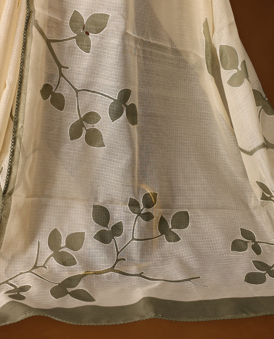 Cream colour Tussar cotton Kota saree featuring elegant Olive green leafy branch motifs across the body, accentuated with a subtle Olive green border, and paired with a matching blouse for a graceful and minimal look.