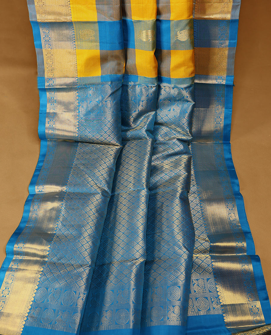 Blue and yellow Checked pure traditional Kancheepuram silk saree featuring antique zari peacock and chakkram motifs on the body, complemented by a traditional border adorned with peacock and diamond motifs, and paired with a matching blouse.