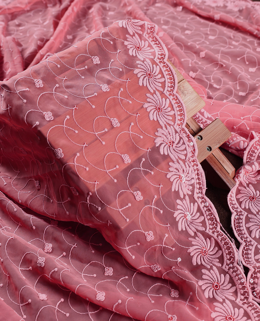 Charming coral pink churidhar material embellished with intricate floral embroidery and detailed thread patterns, paired with a plain matching bottom and embroidered dupatta, ideal for festive and elegant occasions.