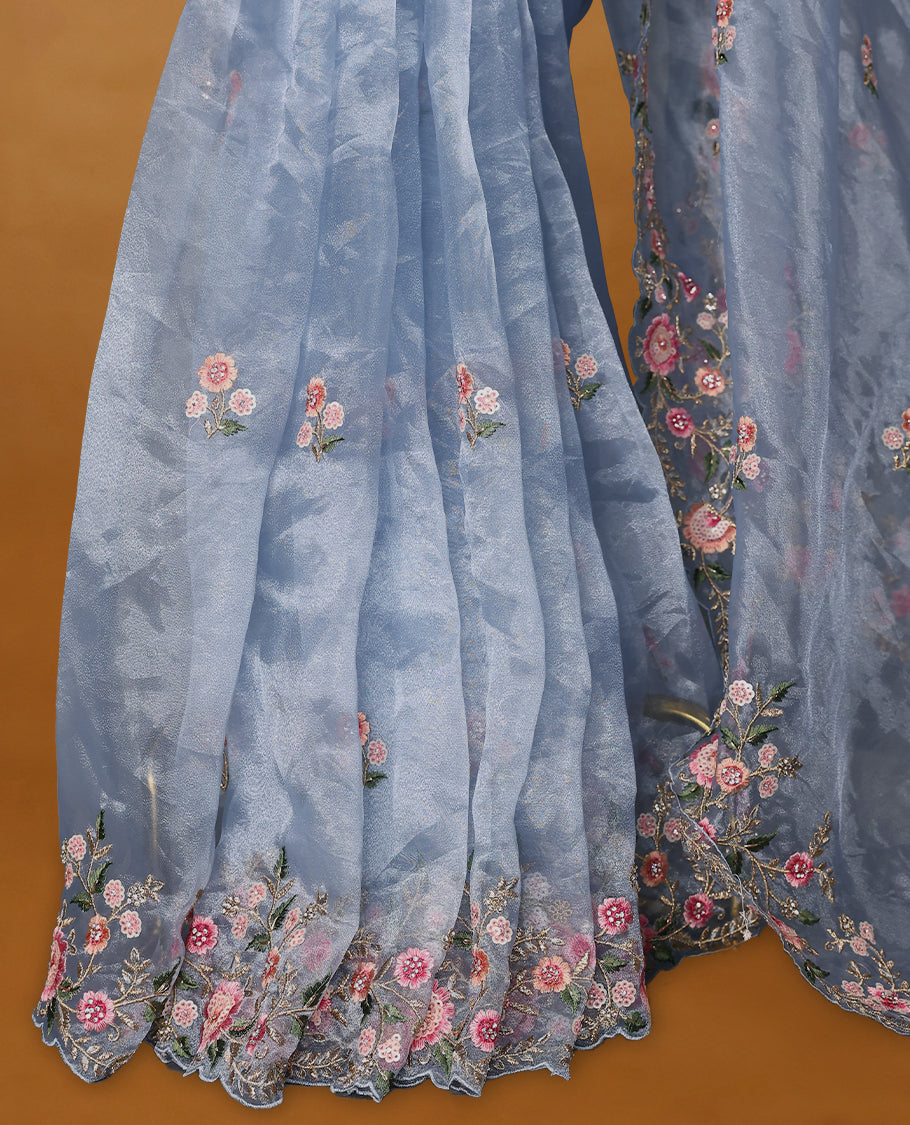 Powder Blue Organza Tissue Silk Saree is beautifully adorned with intricate pink floral embroidery Border and a matching blouse.