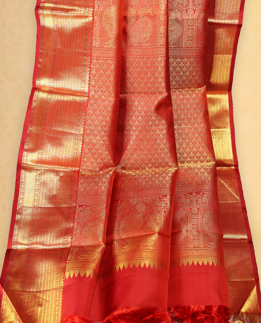 Deep red colour pure Kancheepuram traditional saree featuring gold zari Mayoora Chakra motifs across the body, enhanced with a classic traditional border and a grand pallu woven with Kuttumayil and Sayagata designs, paired with a matching blouse.