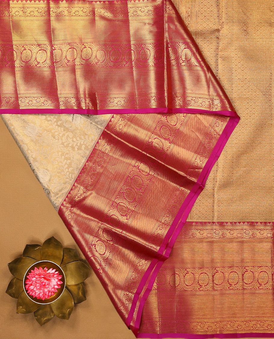 Golden Colour Kancheepuram tissue silk saree adorned with intricate silver and gold zari floral jaal work on the body, enhanced by a contrasting traditional floral kodi design border, paired with a matching blouse.