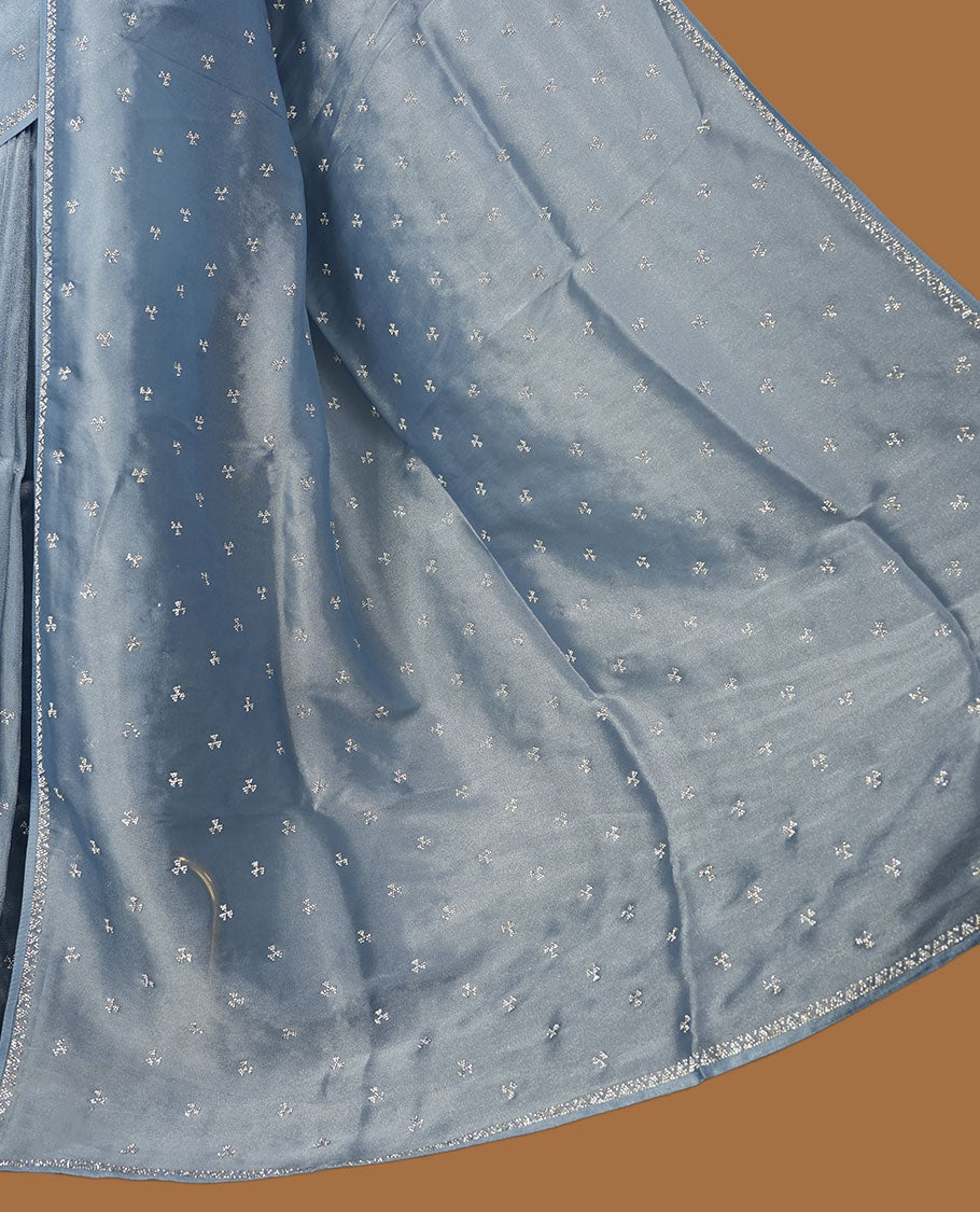 Pastel Blue colour net shimmer fancy saree adorned with scattered white stone buttas all over the body, paired with a delicate stone worked border and matching blouse featuring floral vine stone embroidery