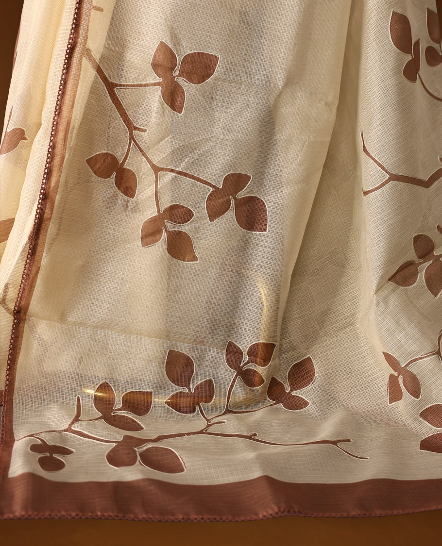 Cream colour Tussar cotton Kota saree featuring delicate Block printed leaves motifs across the body, highlighted with a subtle brown border, paired with a matching blouse.
