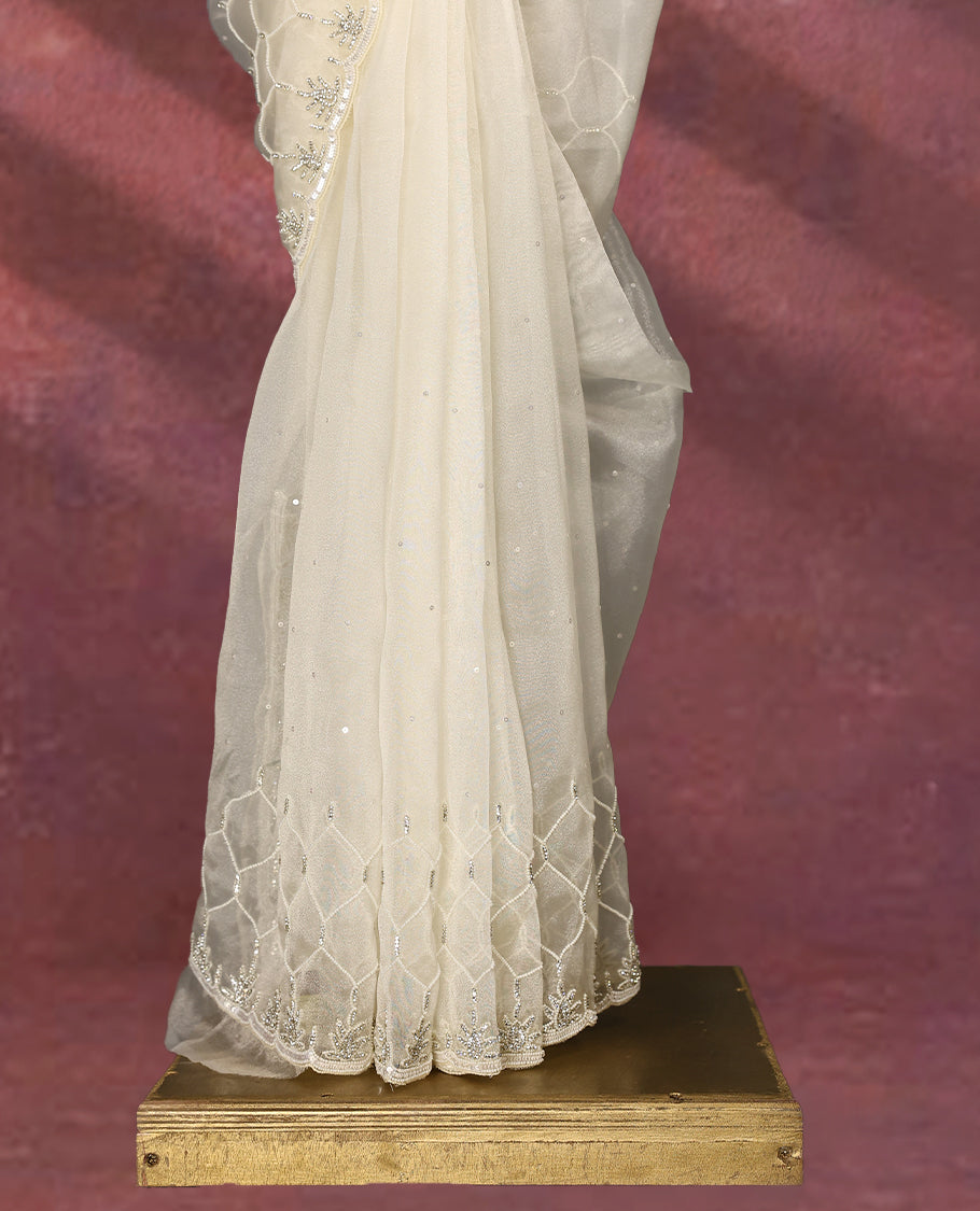 White colour pure organza saree featuring sequin work all over the body, adorned with a heavily embellished border with beads, stones, and sequins, complemented by a worked pallu and paired with a matching embellished blouse