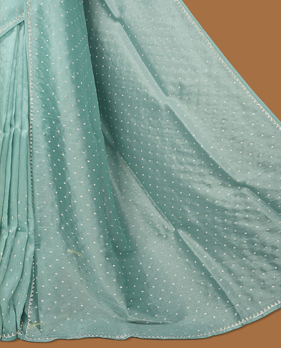 Pastel teal colour net shimmer fancy saree adorned with scattered white stone buttas all over the body, paired with a delicate stone worked border and matching blouse.