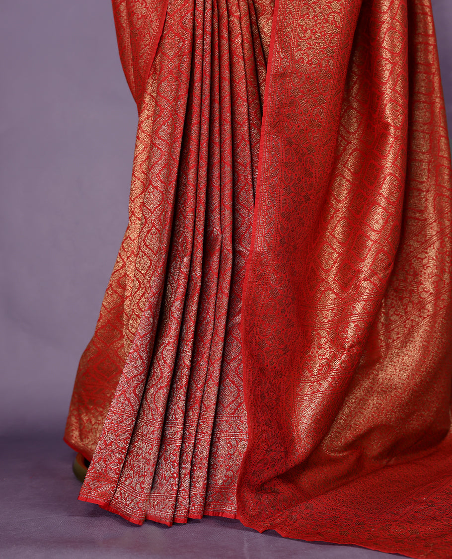 Deep Red colour semi Banaras Katan saree featuring an antique Gold zari jacquard body, complemented by a self colour traditional border with a floral kodi design, paired with a matching blouse