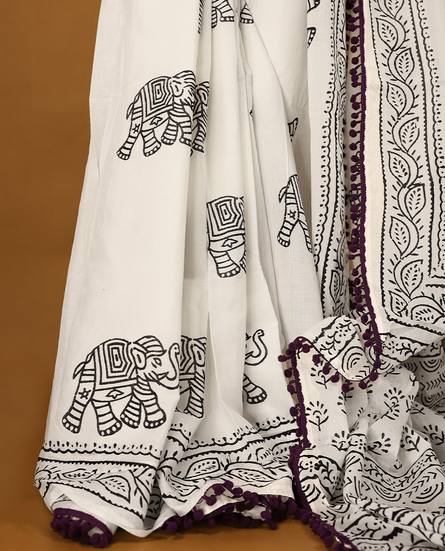 White cotton saree features intricate black elephant handblock prints, a beautifully detailed border with dark grape piping and Self Coloured Blouse