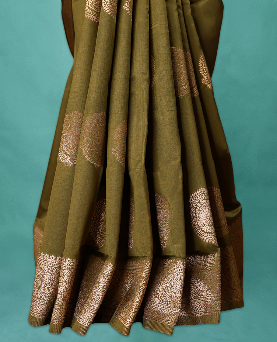 Olive Green coloured semi silk saree featuring a Golden Zari Butta design on the body, paired with a Self coloured border and matching blouse.