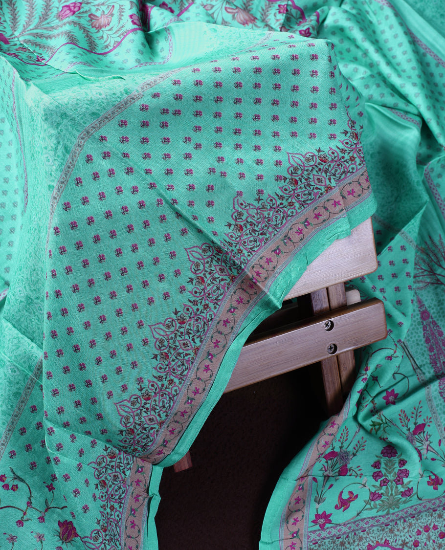 Sea green colour churidhar material featuring delicate peach prints and fine embroidery on the neckline, paired with a matching printed dupatta and plain bottom.