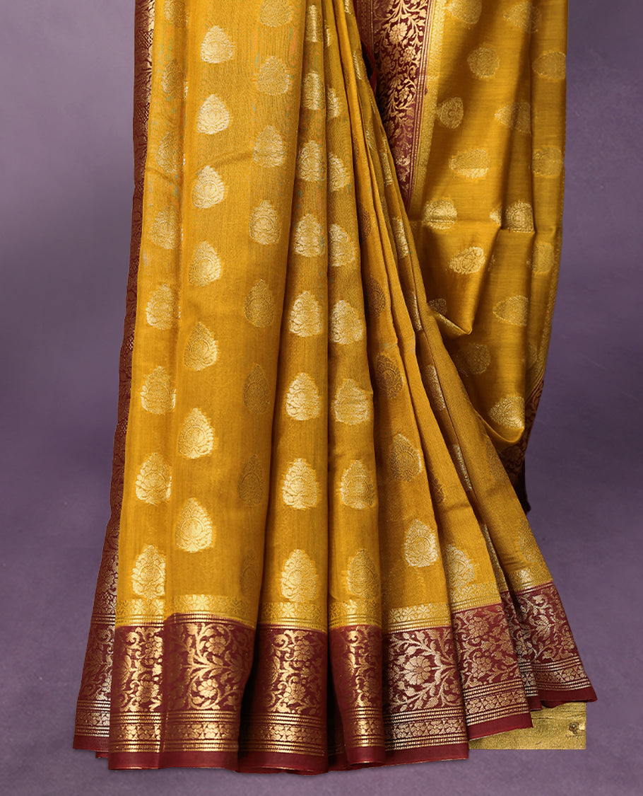Mustard colour pure Banarasi Chanderi cotton fabric, featuring traditional antique zari buttas on the body, complemented by a traditional Maroon Colour border and a matching blouse.