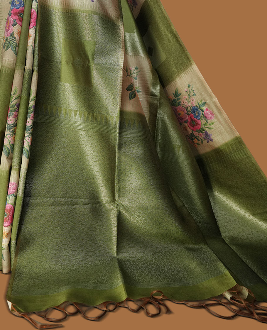 Green color semi tussar Banarasi saree featuring vibrant multi-color floral prints across the body, with shimmering geometric zari patterns, and a matching blouse detailed with silver woven buttas.