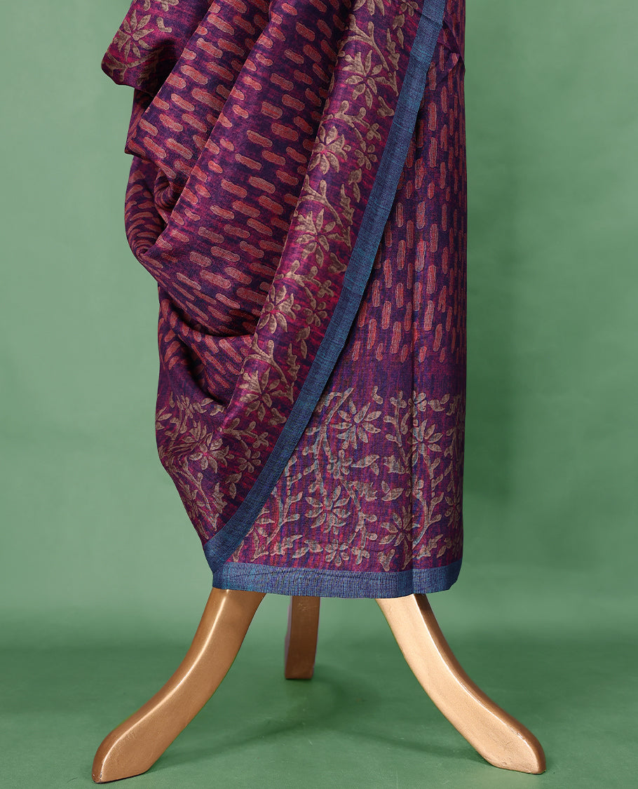 Plum purple colour Manipuri saree features a body with brick-red abstract motifs, highlighted by a contrasting indigo border and floral-printed pallu, and comes with a matching blouse.