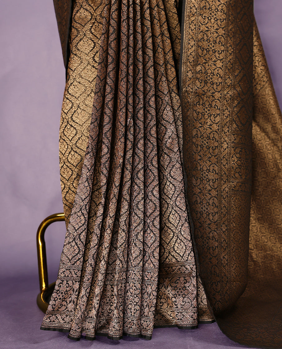 Black colour semi Banaras Katan saree featuring an antique Gold zari jacquard body, complemented by a self colour traditional border with a floral kodi design, paired with a matching blouse