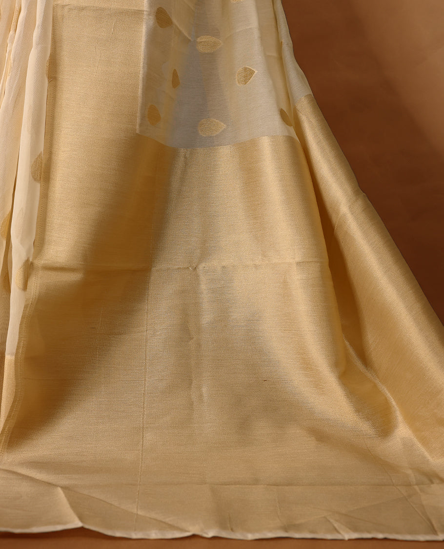 Light gold colour Organza Kerala saree featuring Gold zari Motifs on the body, Gold Kasavu border, Comes paired with a coordinated matching blouse.