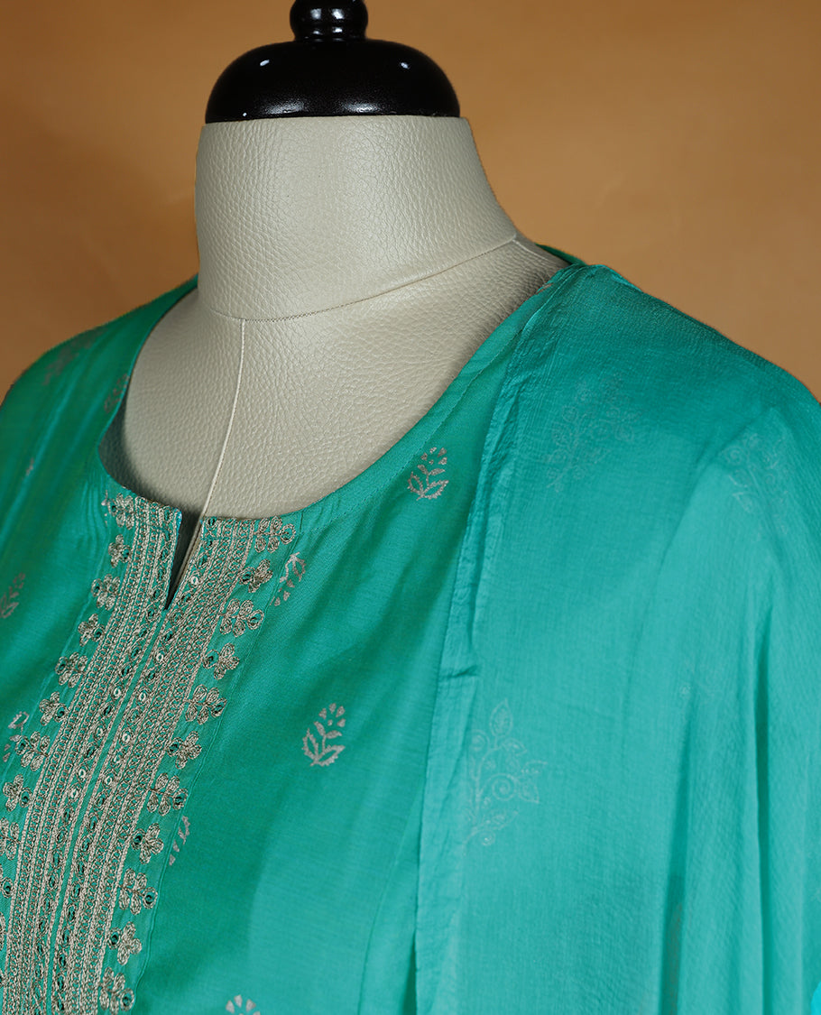 Aqua green colour salwar from TWARA, featuring a round neck adorned with sequins and thread work, with floral prints on the top, paired with a matching bottom and dupatta.