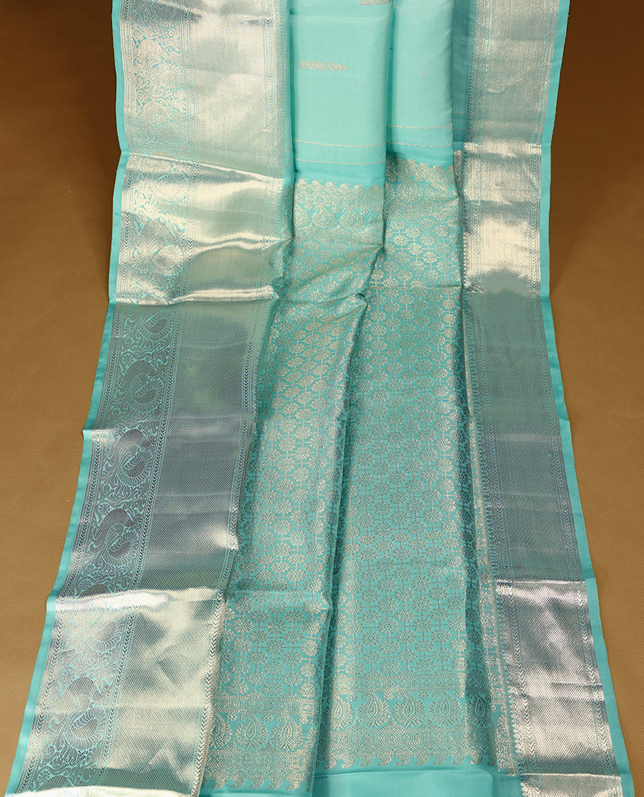 Light aqua Colour pure traditional Kancheepuram silk saree embellished with antique zari motifs on the body, gracefully complemented by a traditional peacock design border, and paired with a matching blouse.
