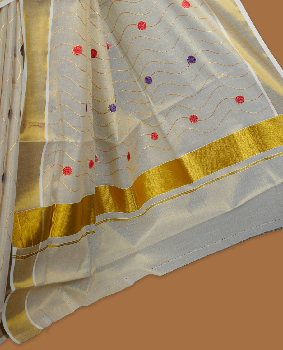 Off white colour cotton Kerala saree with wavy zari lines and colourful red and purple motifs, complemented by a classic golden zari border and matching blouse.