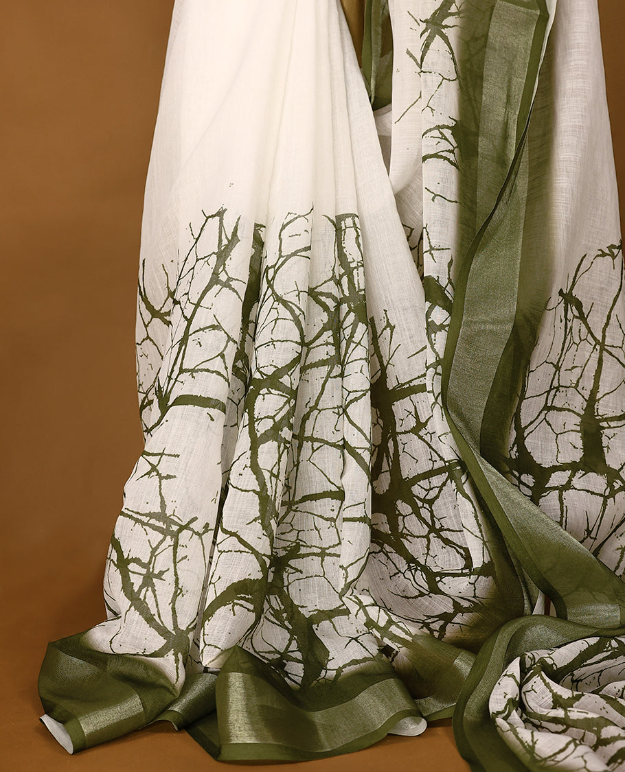 White cotton saree adorned with green abstract patterns and a rich green border with Matching Blouse