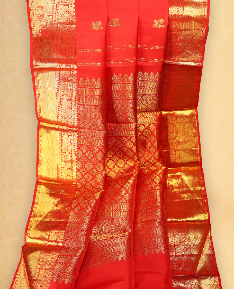 Chilly red colour pure Kancheepuram saree with gold zari Mayoora Chakra motifs on the body, traditional border with peacock and diagonal line patterns, grand pallu with Chathurakamalam and Thilakam, paired with matching blouse.