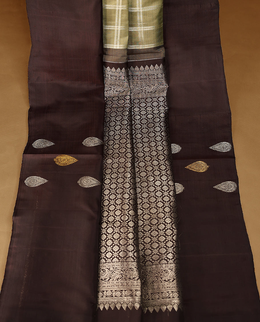 Pastel olive Colour traditional Kancheepuram silk saree adorned with antique check patterns on the body, featuring a deep brown simple border with paisley motifs, and paired with a matching blouse.
