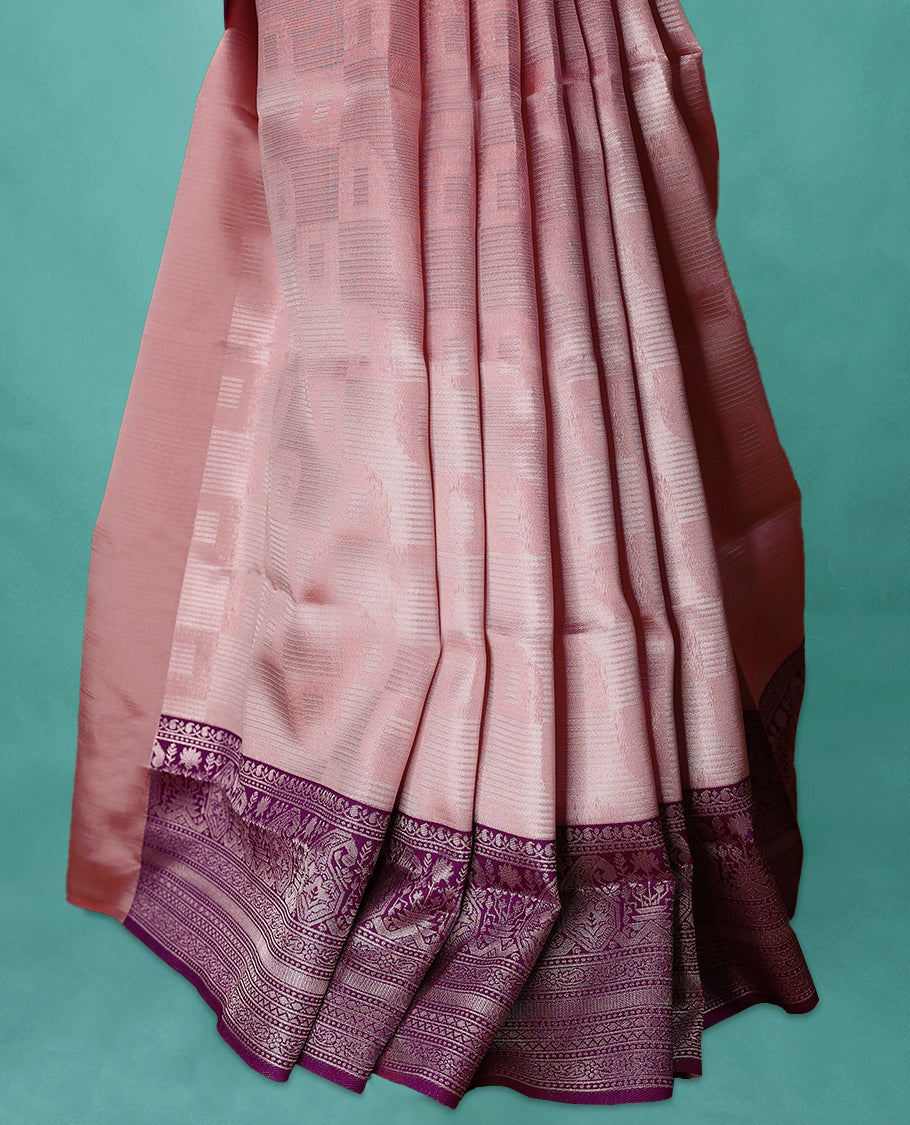 Pastel Peach coloured semi silk saree featuring a Silver coloured Zari design on the body, paired with a Grape coloured border and matching blouse.