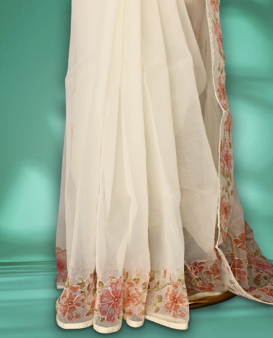 Ivory white colour organza saree adorned with Peach floral print with thread detailing on the border and pallu, in a sheer finish that adds elegance, paired with a matching blouse for a graceful look.