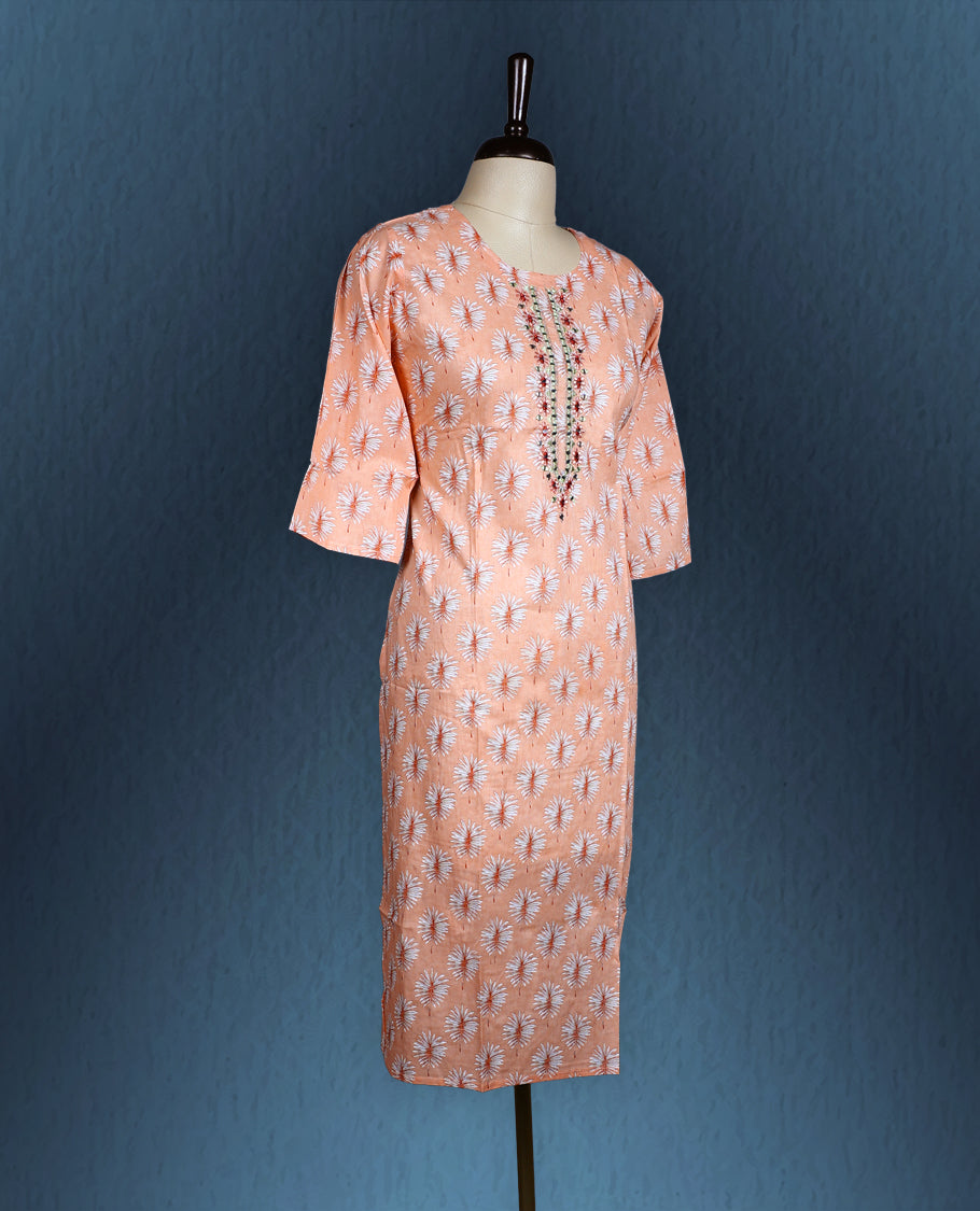 Peach colour kurti with all over white floral prints, featuring a round neckline adorned with vertical thread and mirror embroidery, and three quarter sleeves